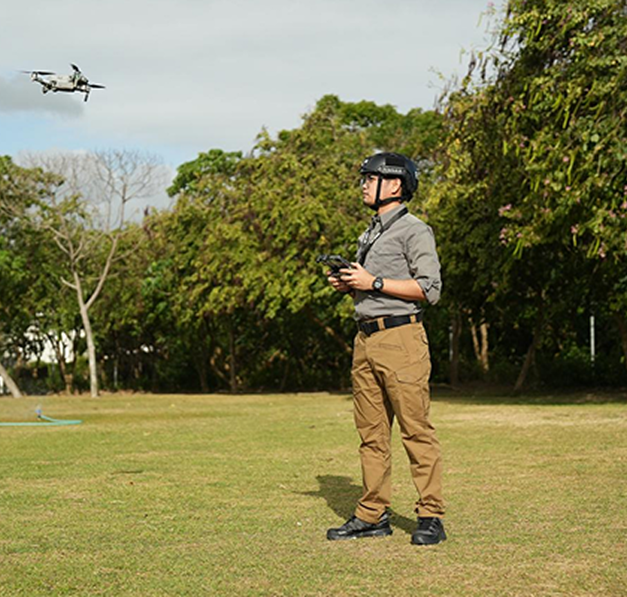 A drone pilot operating a quadcopter in an open field